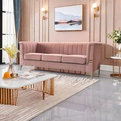 a living room with pink walls and gold trim on the couches, coffee table and rug