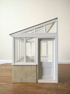 a white doll house sitting on top of a wooden floor