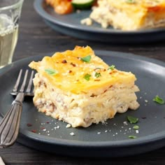 two plates with lasagna casserole on them, one has a fork