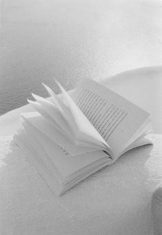 a stack of books sitting on top of a white table next to a cup and saucer