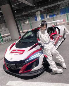 a woman standing next to a white and red sports car