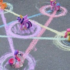 some little ponys are standing in the middle of a chalk drawing on the ground