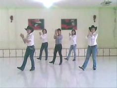 a group of people standing on top of a white floor in front of a wall