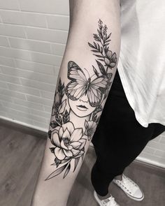 a woman's arm with flowers and butterflies on it