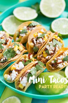 mini tacos on a plate with limes and cilantro in the background