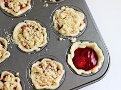 muffins with crumbs and jelly in the middle on a baking tray