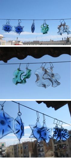 some glass ornaments are hanging in the air on a line with buildings in the background