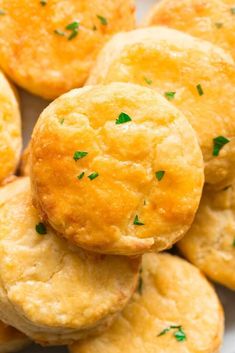 small biscuits are piled on top of each other with parsley sprinkled on them