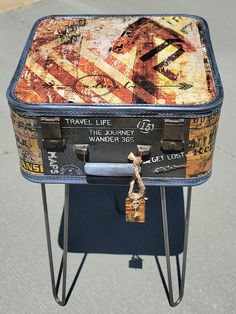 an old suitcase sitting on top of a metal stand