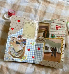 an open scrapbook with pictures and other things on the table next to some pens