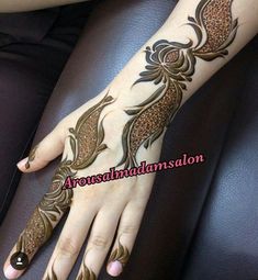 a woman's hand with henna tattoos on it