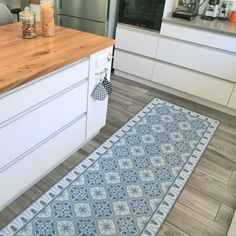 a kitchen area with wooden counter tops and white cupboards, an oven and dishwasher in the background