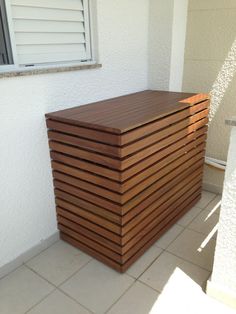 a large wooden box sitting on top of a tiled floor next to a white wall