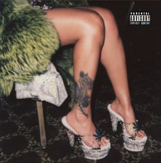 a woman's legs with tattoos and high heels