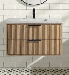 a bathroom vanity with a round mirror above it and tiled flooring in the background