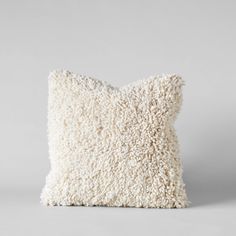 a white pillow that is made out of sheepskin and has been placed on the floor