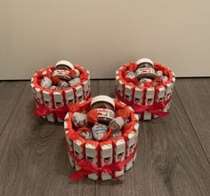 three wrapped cakes sitting on top of a wooden floor