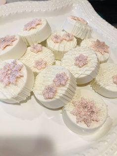 there are many white and pink cakes on the plate