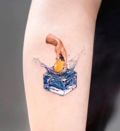 a woman's arm with a piece of cake and an orange on top of it