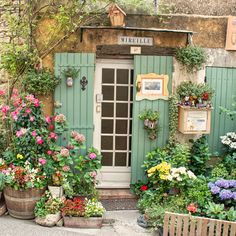 an old building with potted plants in front of it and a sign on the door