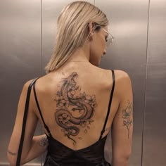 a woman with a dragon tattoo on her back