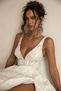 a woman in a white dress posing for the camera