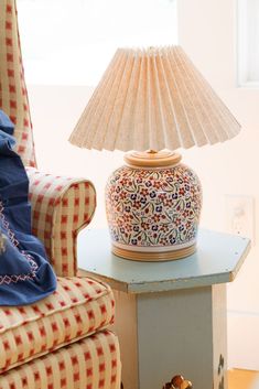 a lamp sitting on top of a table next to a chair