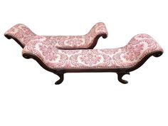 a pair of pink and white chaise lounges with floral print on the back