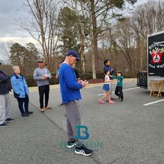 a man standing in the middle of a parking lot talking to people on their cell phones