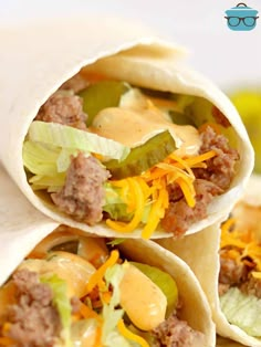 three burritos filled with meat, cheese and lettuce