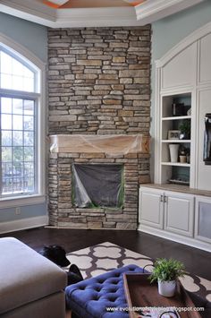 a living room filled with furniture and a fire place in front of a stone fireplace