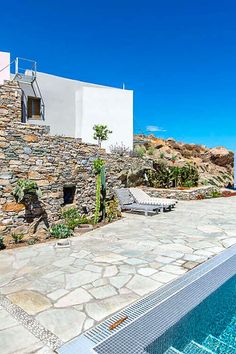 an outdoor swimming pool next to a stone building