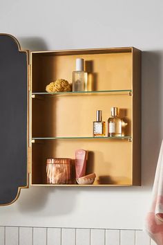 an open wooden medicine cabinet next to a mirror