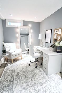 a white desk and chair in a room with gray walls, rugs and pictures on the wall