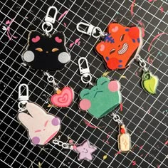 several keychains with different designs on them sitting on a black surface next to confetti sprinkles