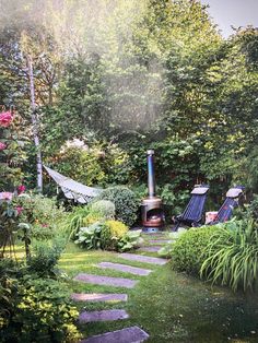 an outdoor fireplace in the middle of a garden with stepping stones leading up to it