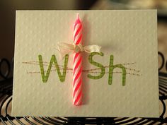 a close up of a birthday card with a candle on it and the word w ish