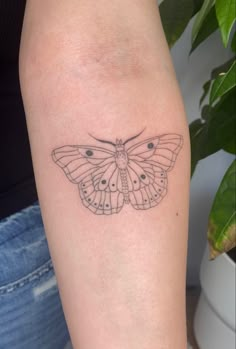 a small butterfly tattoo on the arm