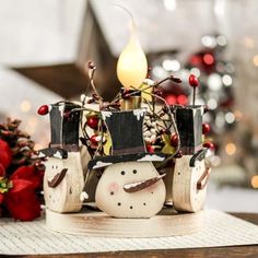 a christmas scene with a candle and snowman figurines