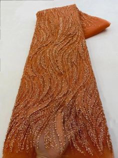 an orange piece of cloth with gold sequins on it