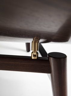 the back end of a wooden table with brass hardware