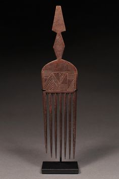 an old wooden comb with long hair on it's head and two arrows in the back