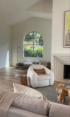 a living room with white furniture and a large window in the wall next to it