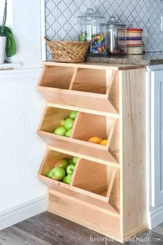 a wooden shelf filled with apples on top of a counter