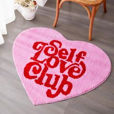 a pink heart shaped rug with the words love club written on it in red ink