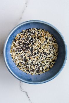 a blue bowl filled with food on top of a white counter