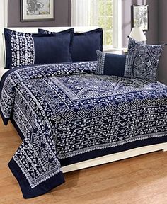 a blue and white comforter set on a bed