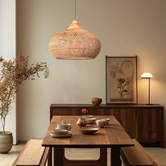 a dining room table with two benches and a light hanging from the ceiling over it