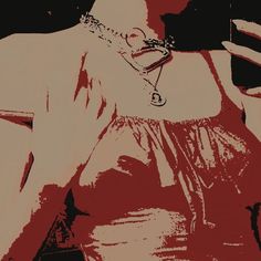 a woman in a red dress holding a cell phone to her ear and wearing a chain around her neck