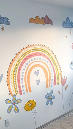 the wall has been painted with flowers, hearts and rainbows on it in an otherwise empty room